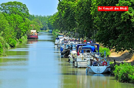 Boten varen op het Canal du Midi, omzoomd met groene bomen, nabij Carnon (34).
