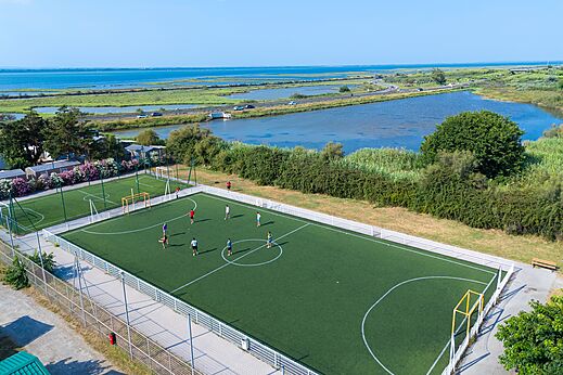 Synthetisch multisportterrein met spelers, luchtfoto op camping CAPFUN Mille Pépites in Carnon (34).