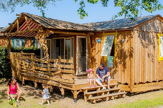 Familie stacaravan met speelterras en kinderen op camping CAPFUN Mille Pépites in Carnon (34).