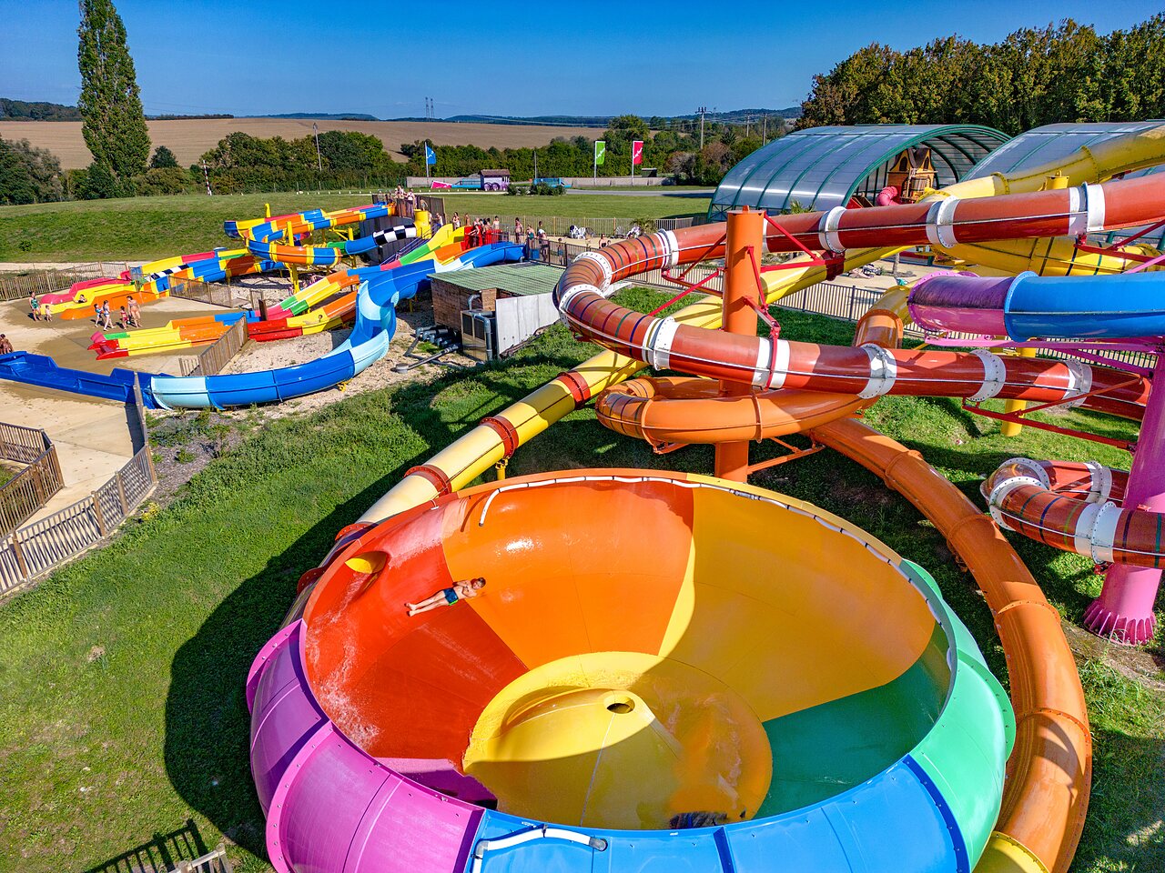 Kleurrijke waterglijbanen en waterspellen op camping CAPFUN Mirabelle in VOLSTROFF (57).