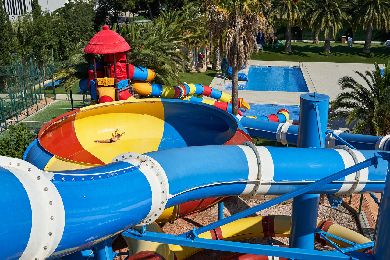 Kleurrijke waterglijbanen en buitenzwembad met kind op camping CAPFUN Mirmanda in Cambrils - Vinyols i els Arcs (43).