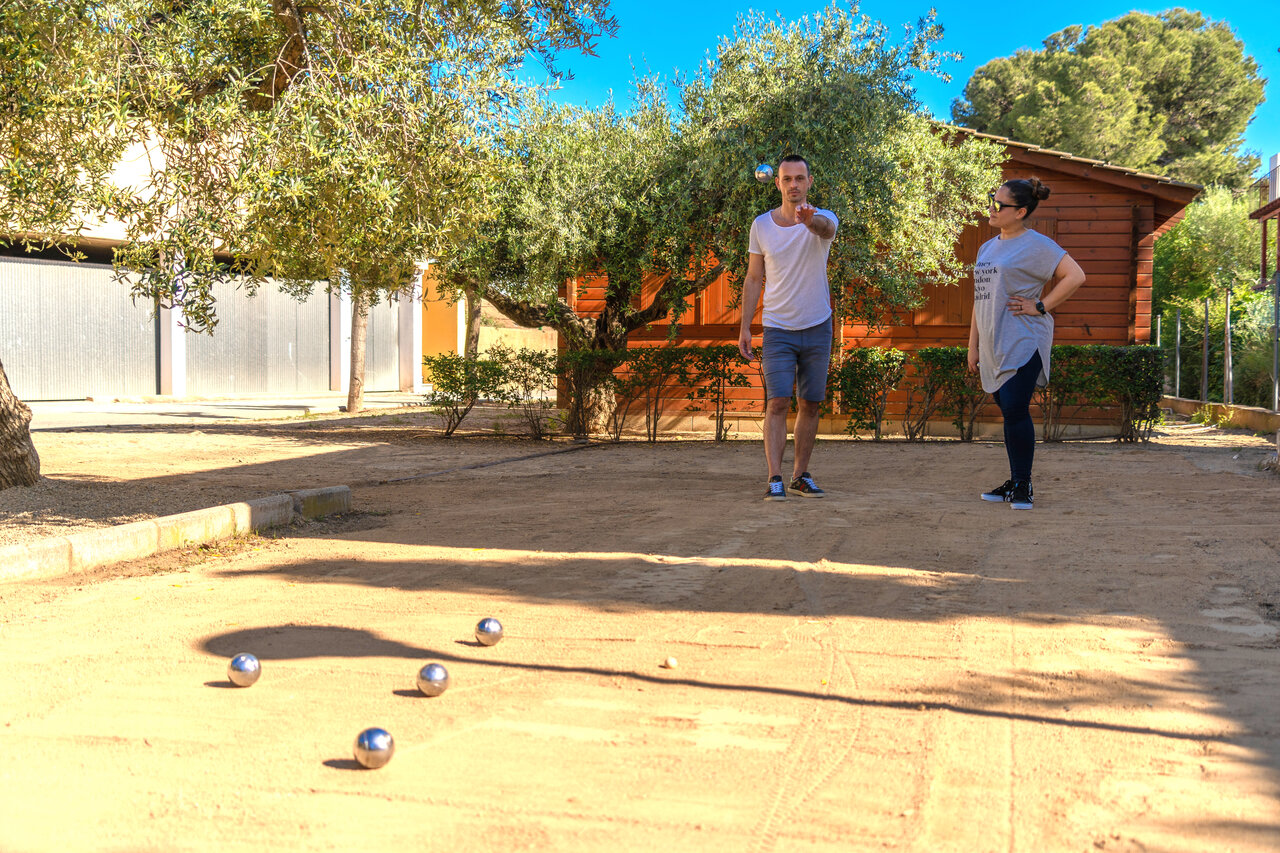 Schaduwrijk jeu de boules terrein met spelers op camping CAPFUN Mirmanda, Cambrils - Vinyols i els Arcs.