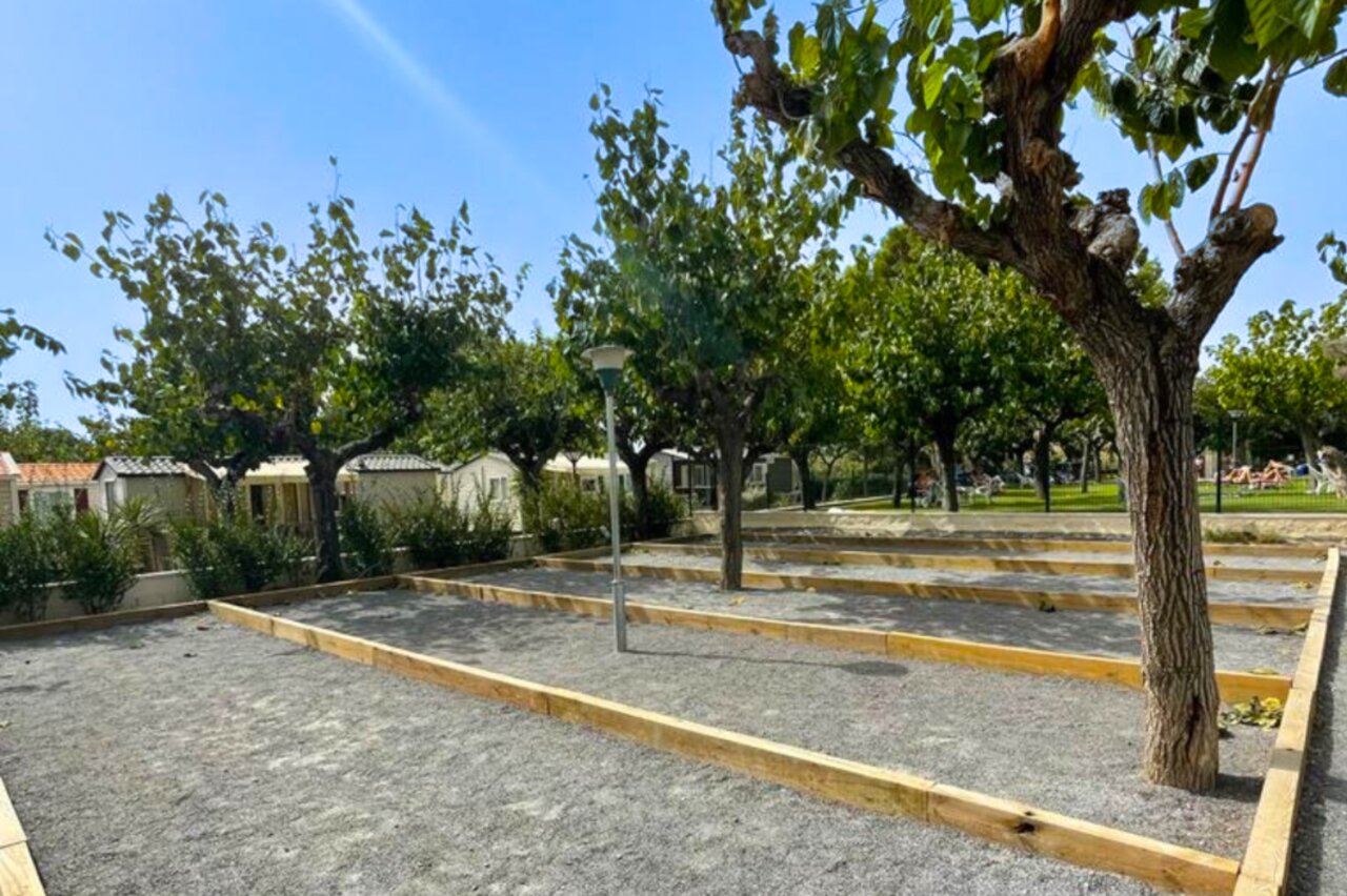 Schaduwrijke jeu de boules banen en stacaravans op camping CAPFUN Mirmanda in Cambrils - Vinyols i els Arcs.