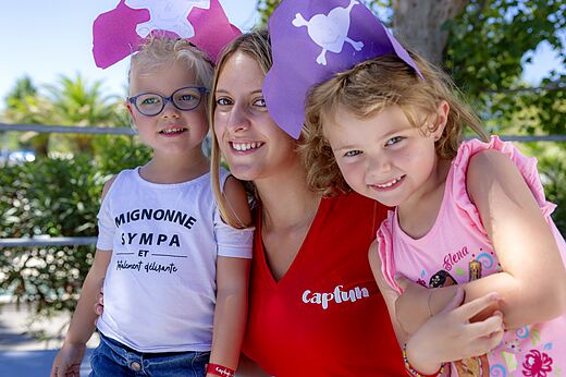 Capfun animator en lachende kinderen met piratenhoeden op CAPFUN Mirmanda.