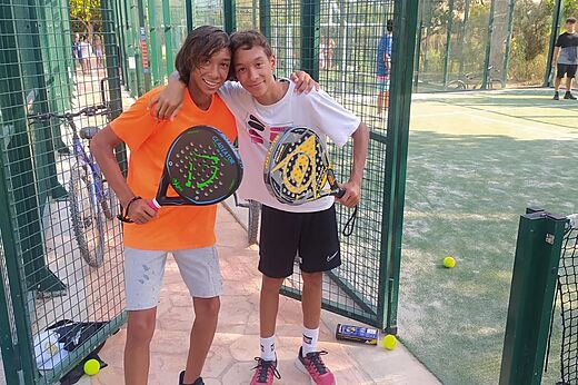 Lachende jonge padelspelers op de baan bij camping CAPFUN Mirmanda in Cambrils.