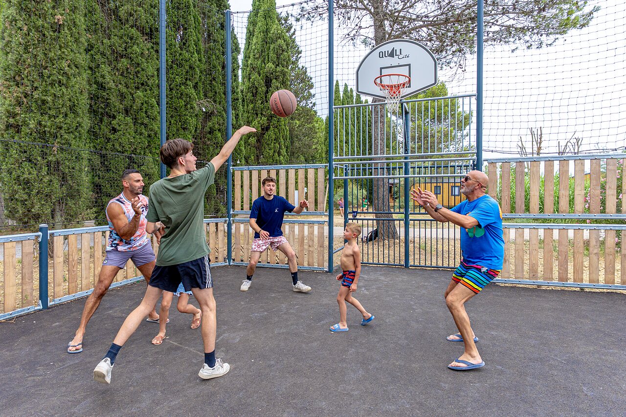 Basketbalveld met familie spelend, gezellige sfeer op camping VAGUES OCEANES Monte Cristo in Vauvert (30).