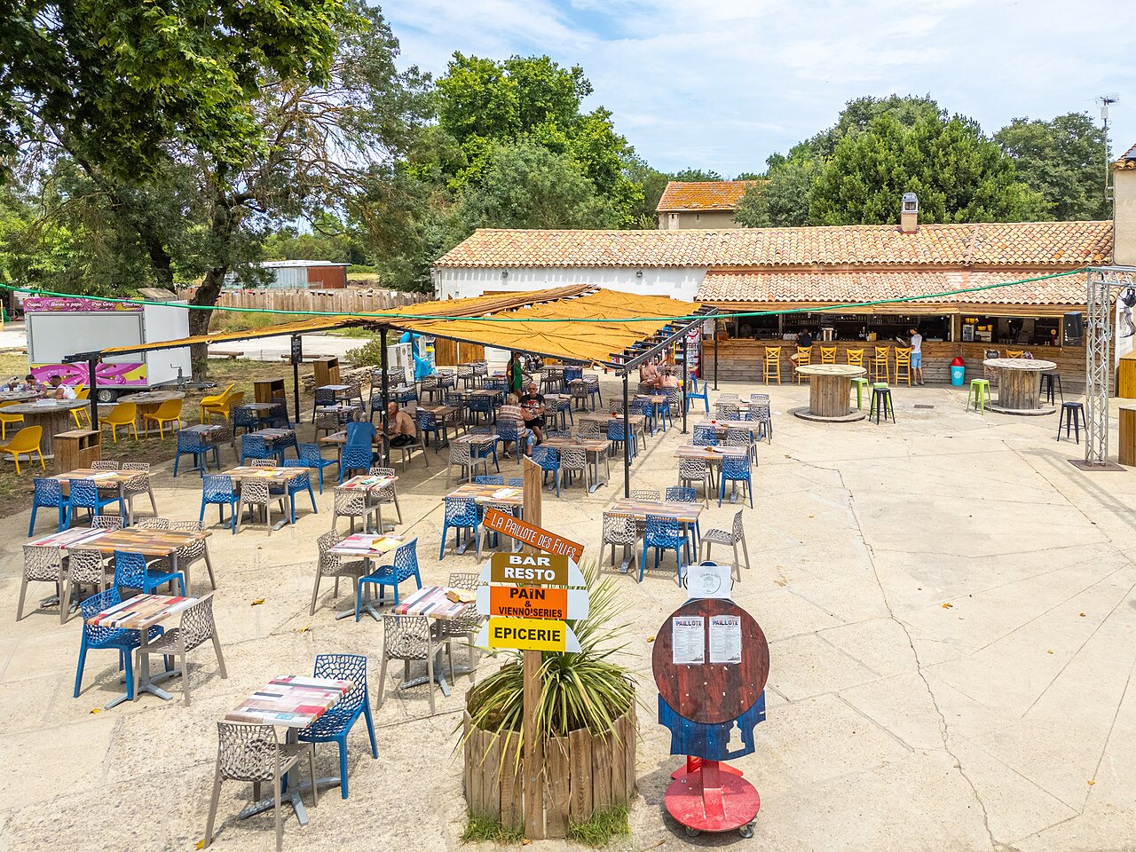 Buitenterras van restaurant, bar en supermarkt op camping VAGUES OCEANES Monte Cristo in Vauvert (30).