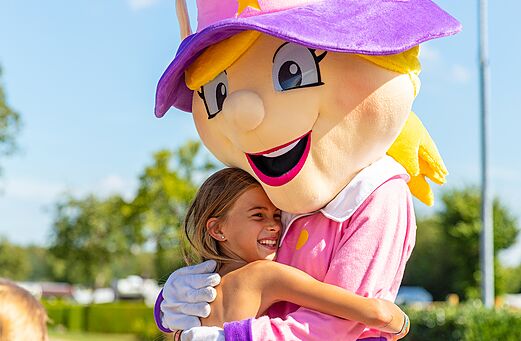 Campingmascotte en lachend kind knuffelen, animatie op camping CAPFUN Montsabert in COUTURES (49).