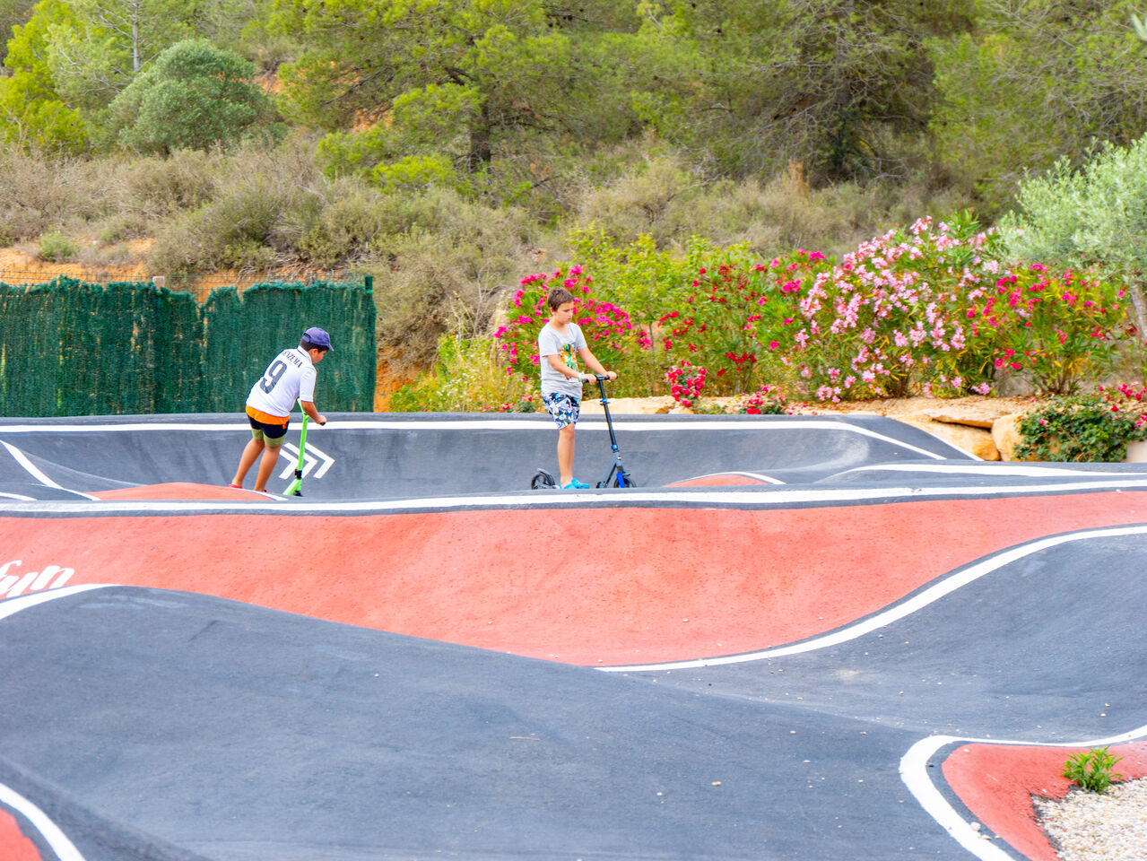 Pump track baan met kinderen op stepjes op camping CAPFUN Montblanc Park in Montblanc (43).