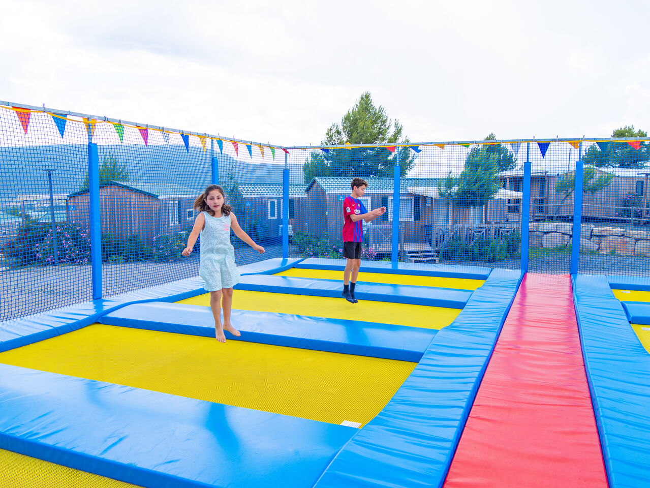Kinderen springen op trampolines, stacaravans achtergrond op camping CAPFUN Montblanc Park in Montblanc (43).
