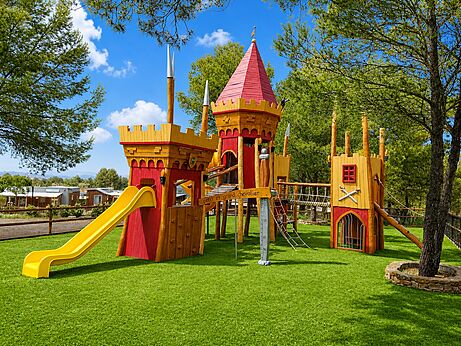 Grote houten kasteelspeeltuin met glijbaan op camping CAPFUN Montblanc Park (43).