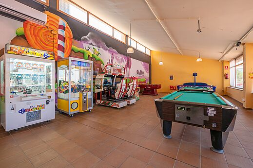 Speelzaal met biljart, tafelvoetbal en arcadekasten op camping CAPFUN Montblanc Park.