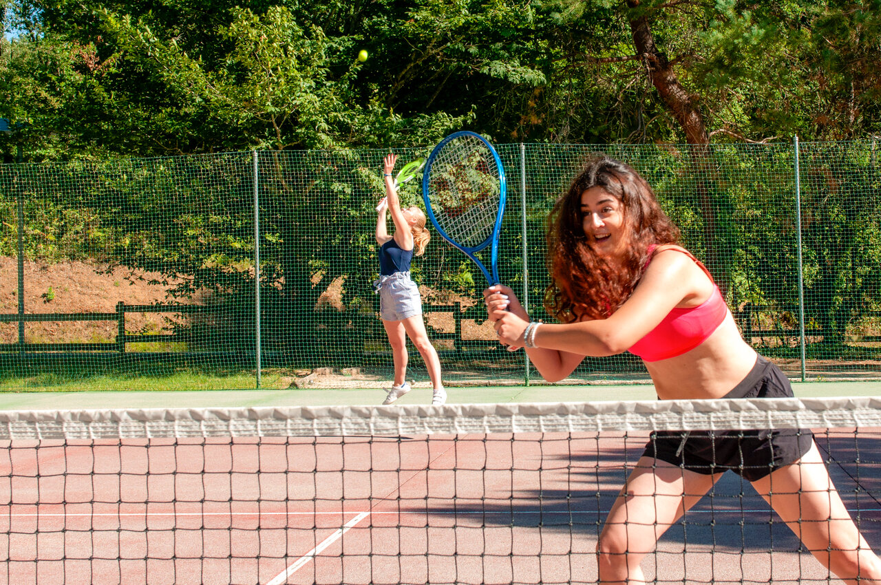 Jonge vrouwen tennissen op zonnige baan, camping CAPFUN Moulinal in BIRON (24).