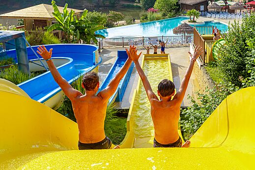 Twee personen op waterglijbanen en zwembad bij CAPFUN Moulinal in BIRON (24).