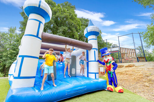 Groot springkasteel met kinderen en mascotte op camping CAPFUN Moulinal in BIRON (24).