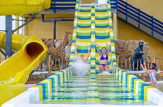 Kleurrijke waterglijbanen en zwemmers op camping VAGUES OCEANES Moulin de Cadillac (56).