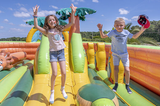 Kinderen springen op een gigantisch opblaasbaar speeltoestel op camping VAGUES OCEANES Moustoir in Carnac (56).