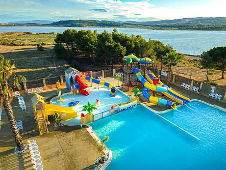 Kleurrijke waterglijbanen en groot buitenzwembad op camping CAPFUN La Nautique in Narbonne (11).