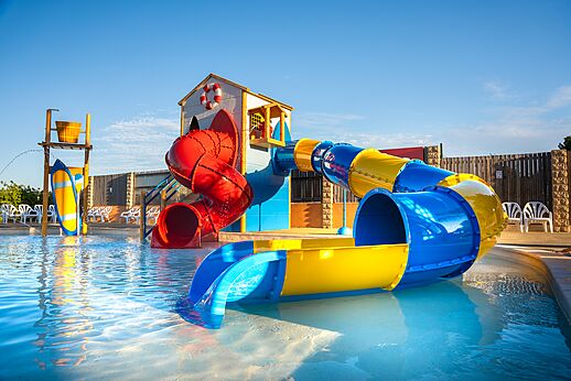 Kleurrijke waterglijbanen en buitenzwembad voor kinderen op camping CAPFUN La Nautique in Narbonne (11).