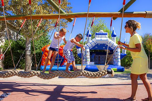 Kinderen op touwbrug en opblaasbare spelen, camping CAPFUN La Nina Agde.