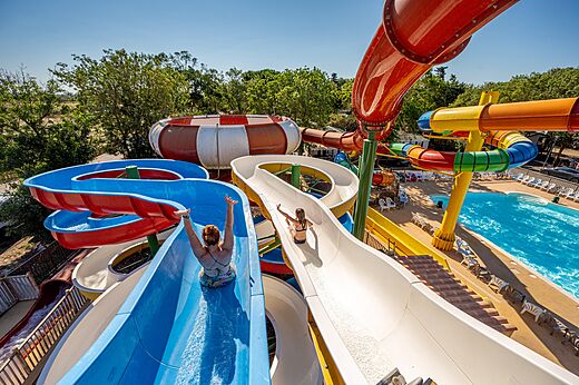 Kleurrijke waterglijbanen en buitenzwembad op camping CAPFUN Ondines in Vias Plage (34).