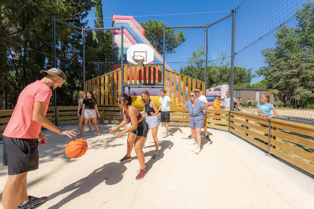 Basketbalveld met jongeren en volwassenen spelend op camping CAPFUN Or in La Grande Motte (34).