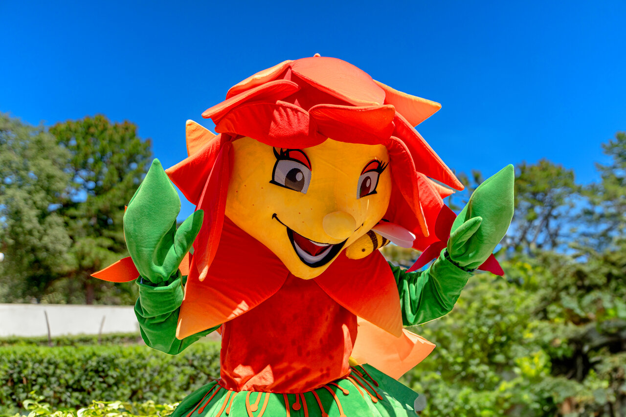Lachende bloemenmascotte met bij op camping CLICOCHIC Or�e d'Azur OPIO (06).