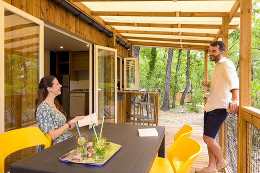 Koppel op terras van moderne stacaravan op camping CLICOCHIC Orée d'Azur in OPIO (06).