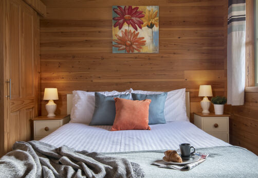 Comfortabele Mobil-home slaapkamer met tweepersoonsbed op camping CAPFUN UK Otter Falls.