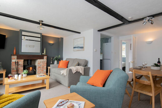 Gezellige woonkamer met open haard, bank en eettafel op camping CAPFUN UK Otter Falls.