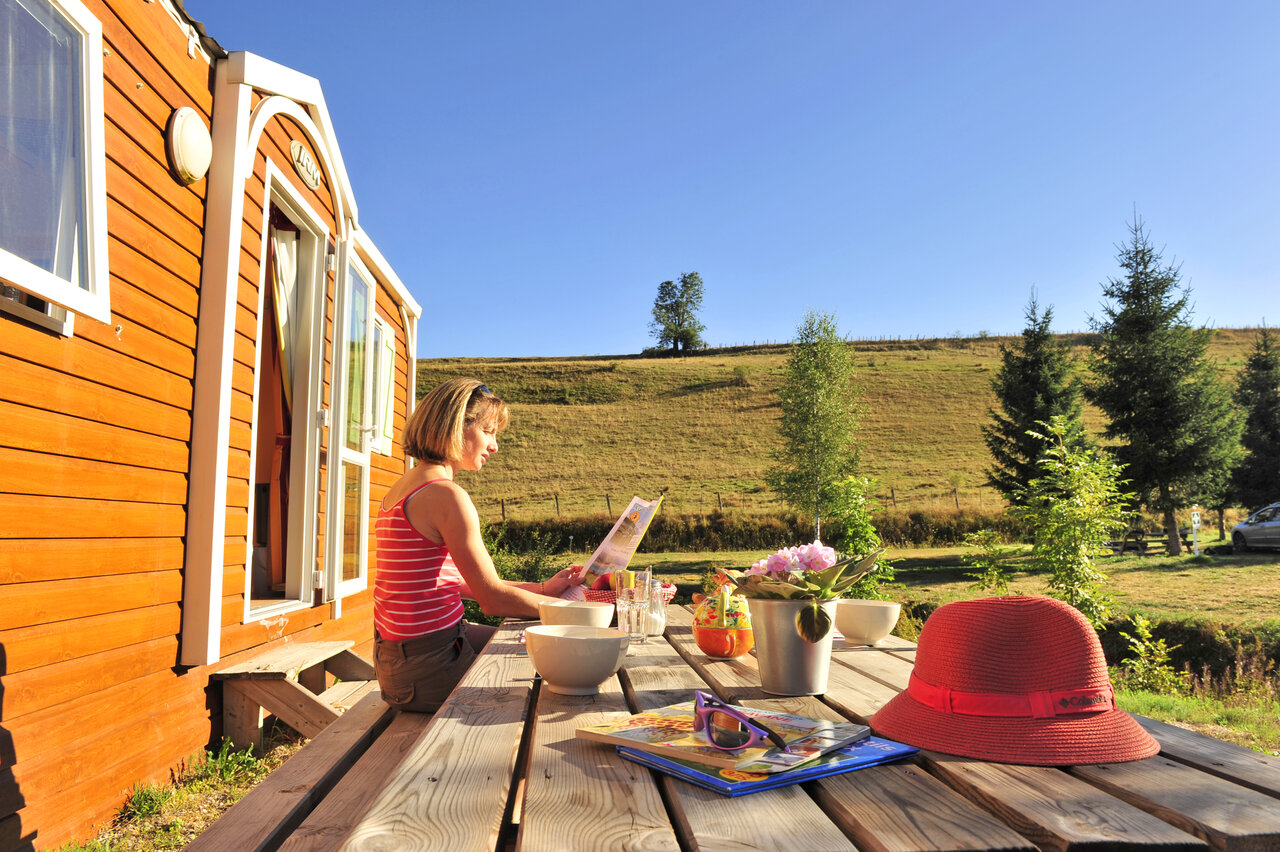 Vrouw op Mobil-home terras, natuurzicht, op camping CAPFUN Oursi�re in Villard de Lans (38).