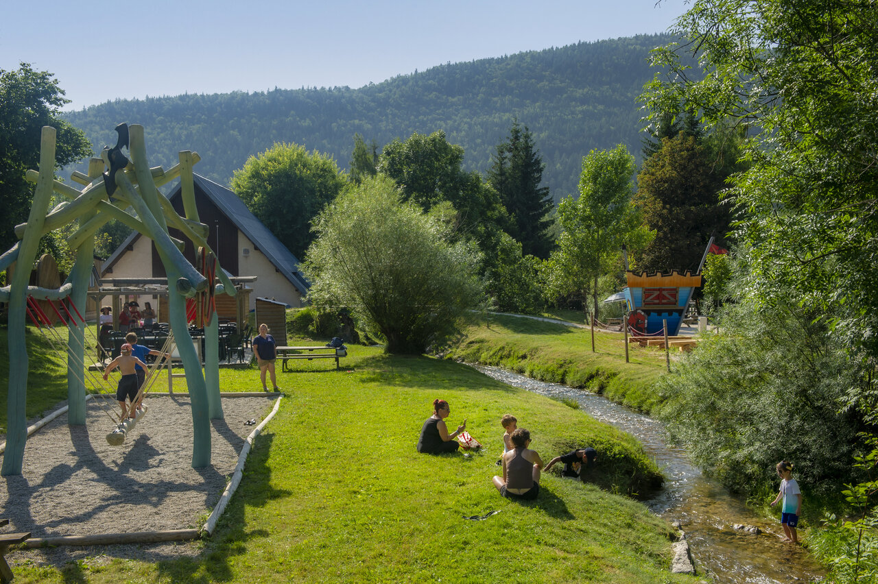 Kinderspeeltuin, beekje en groen op camping CAPFUN Oursi�re in Villard de Lans (38).
