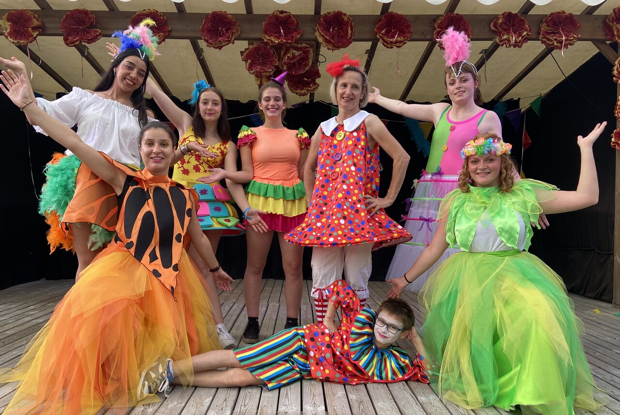 Verkleed animatieteam poseert op podium, feestelijke sfeer op camping CAPFUN Oursi�re in Villard de Lans (38).