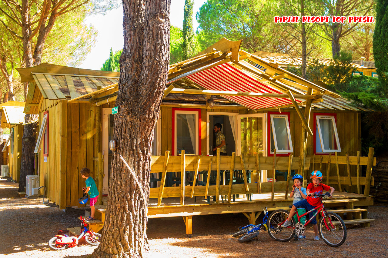 Houten stacaravan, kinderen fietsen op camping CAPFUN Pachacaid in La Mole (83).