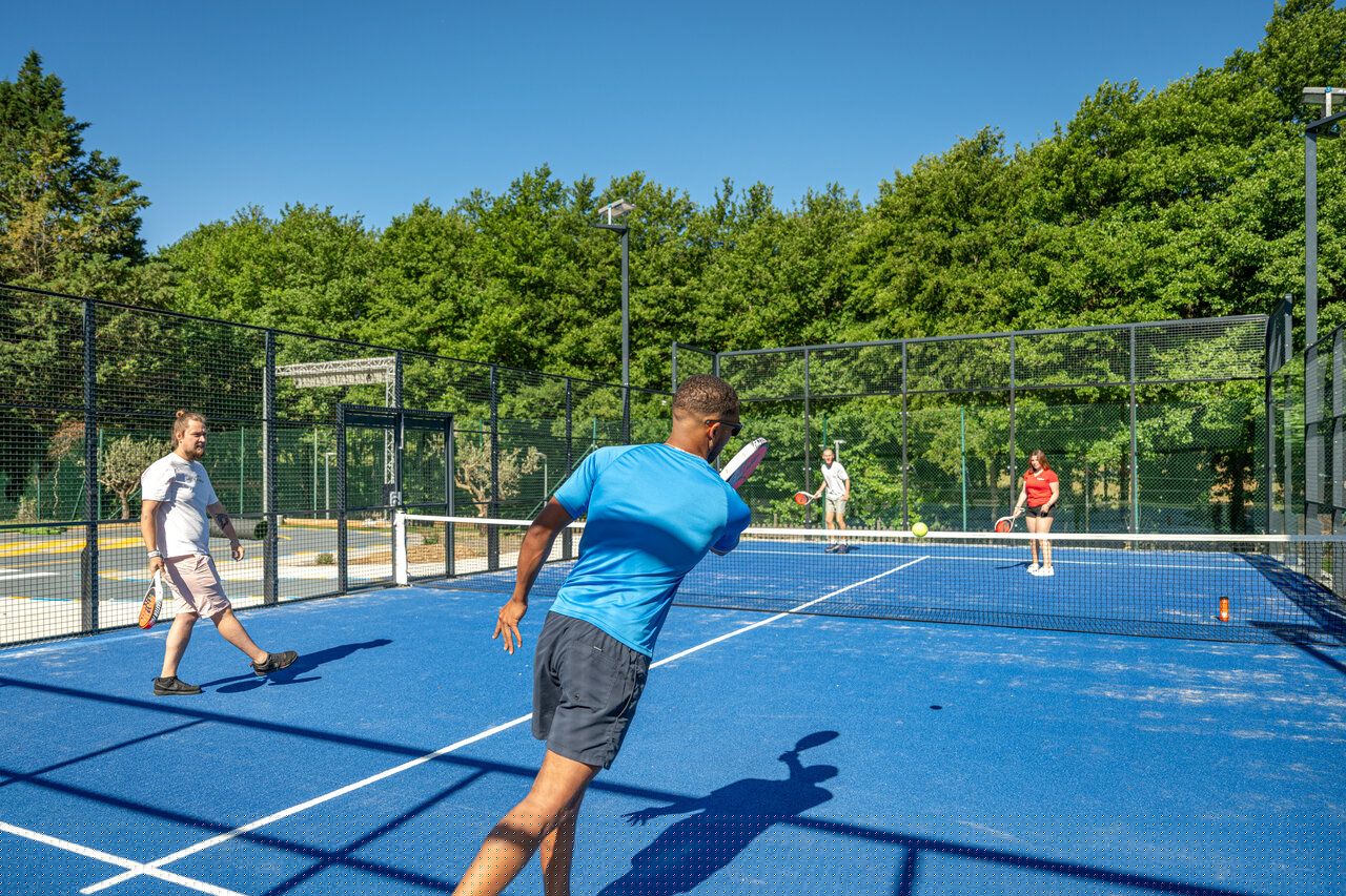 Blauwe padelbaan met vier personen spelend op camping CAPFUN Pachacaid in La Mole (83).