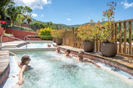 Buitenjacuzzi met bubbels en ontspannende mensen op camping CAPFUN Pachacaid in La Mole (83).