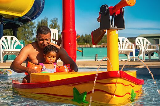 Kind en vader spelen in de waterspeeltuin op camping CAPFUN Pachy in FOSSES LA VILLE.