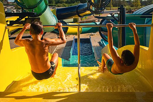 Kinderen glijden van een grote gele waterglijbaan op camping CAPFUN Pachy in FOSSES LA VILLE.
