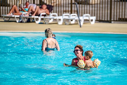 Buitenzwembad met vrouw en kind op camping CAPFUN Pachy in FOSSES LA VILLE.