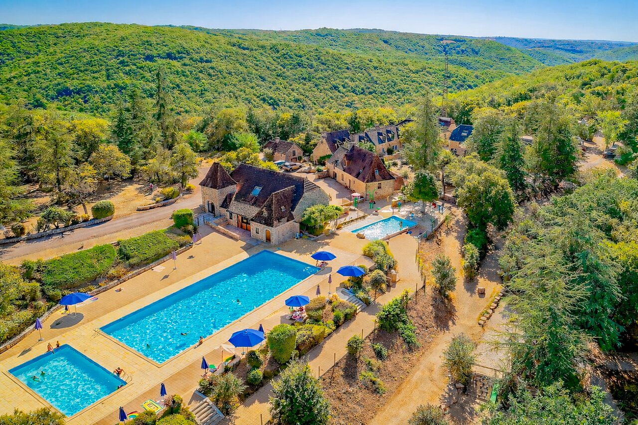 Luchtfoto van buitenzwembaden en gebouwen op camping VAGUES OCEANES Paille Basse in Souillac (46).