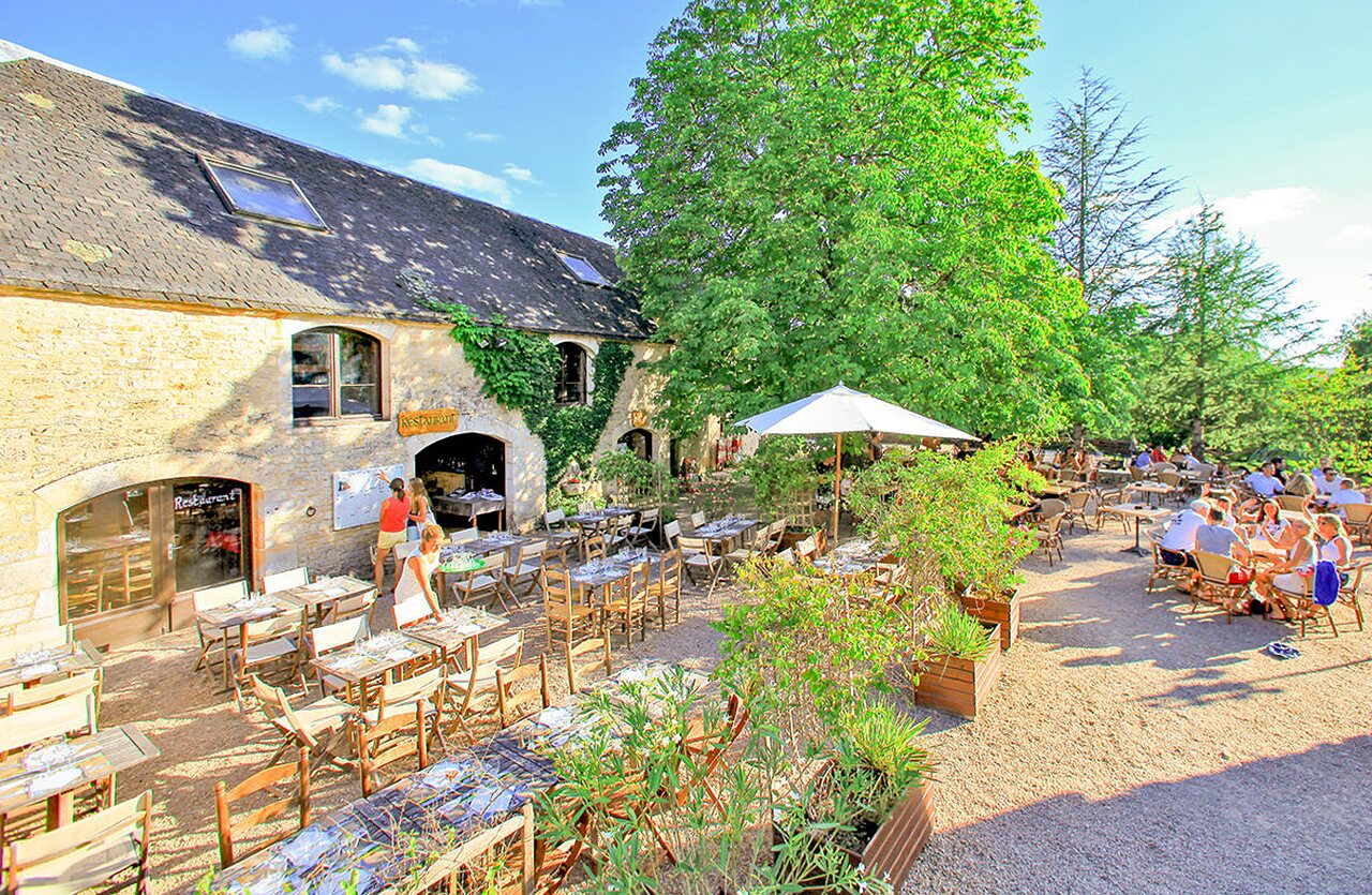 Levendig buitenterras van het restaurant op camping VAGUES OCEANES Paille Basse in Souillac (46).