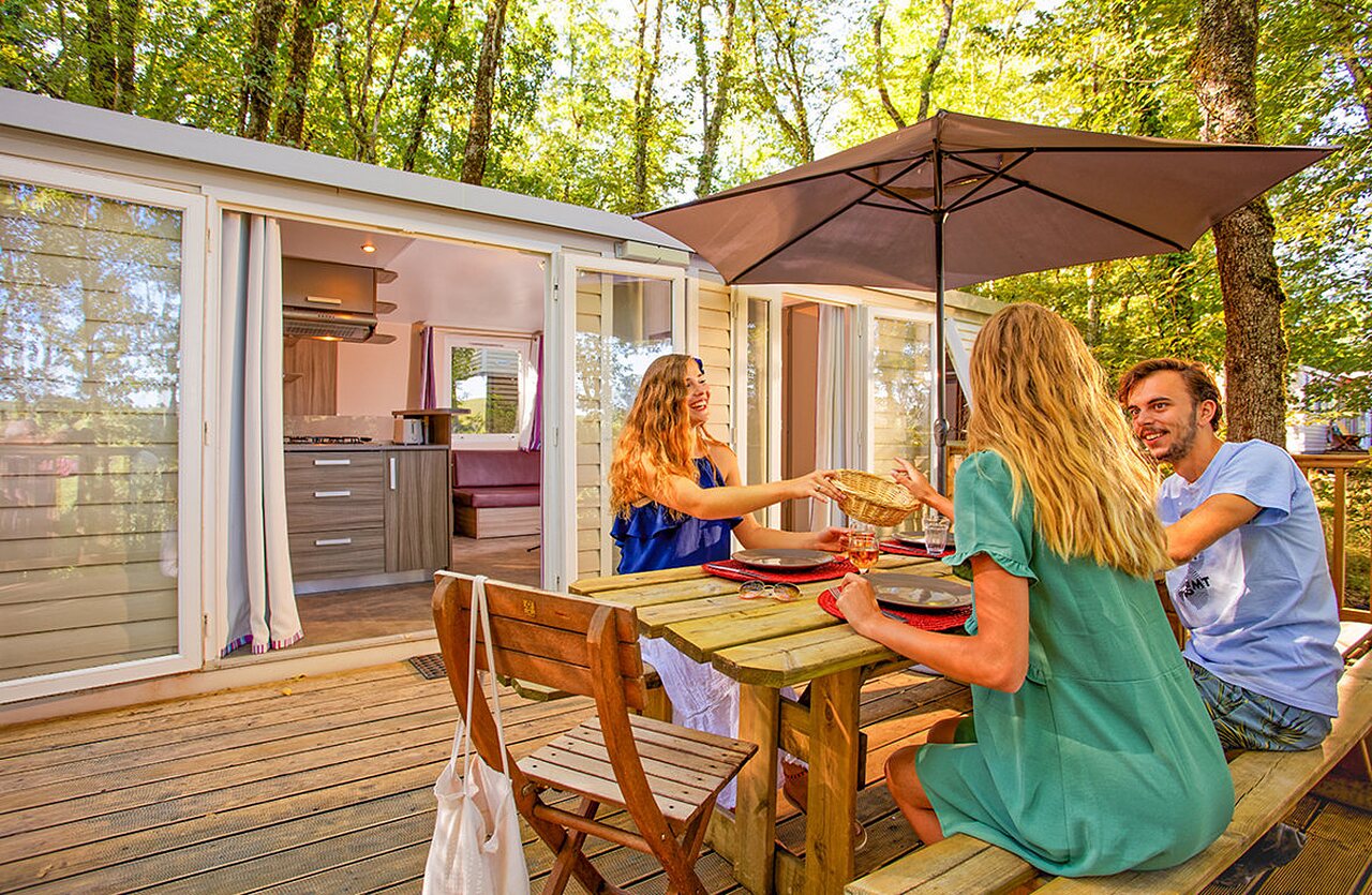 Modern stacaravan, houten terras, familiemaaltijd op camping VAGUES OCEANES Paille Basse.