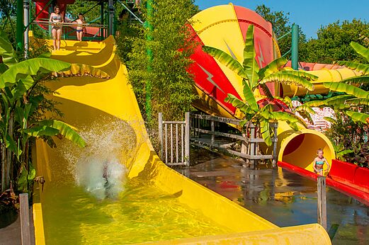 Reusachtige gele en rode waterglijbanen met kinderen op camping CAPFUN Paillotte in AZUR (40).