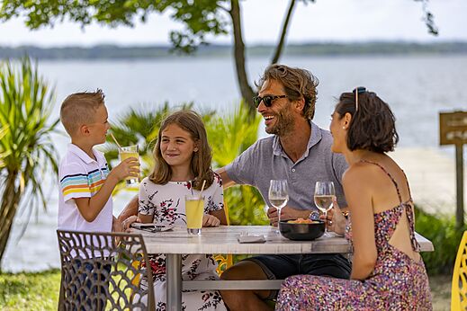 Familie eet op terras van restaurant camping CAPFUN Paillotte in AZUR (40).