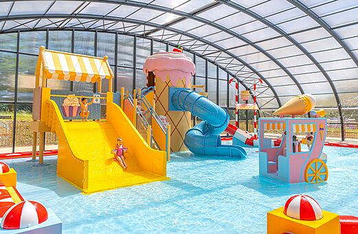 Overdekt zwembad met glijbanen en waterspellen op camping CAPFUN Palais de Gaufrette in Rémering les Puttelange (57).
