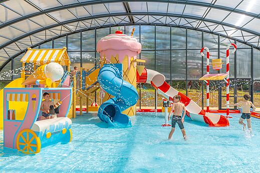 Overdekte waterspeeltuin met glijbanen op camping CAPFUN Palais de Gaufrette in Rémering les Puttelange (57).