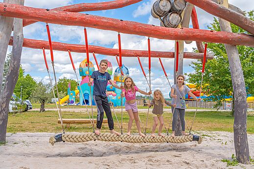 Kinderen op touwschommel van de speeltuin op camping CAPFUN Palais de Gaufrette in Rémering les Puttelange (57).