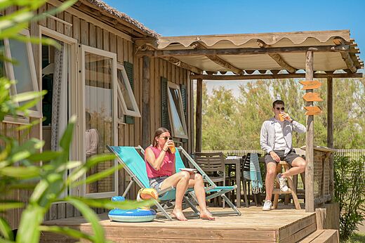 Koppel ontspant op terras stacaravan op camping CLICOCHIC Palmira Beach (34).