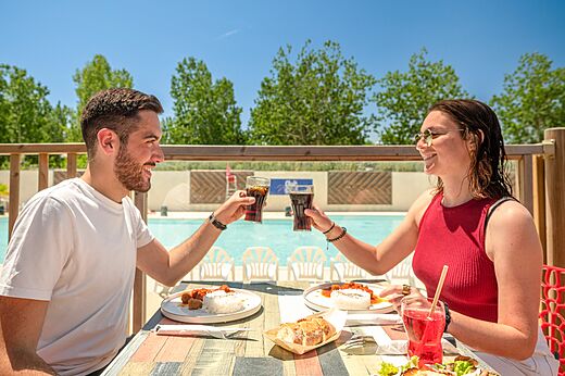 Koppel luncht op restaurantterras bij camping CLICOCHIC Palmira Beach in Vendres-Plage.