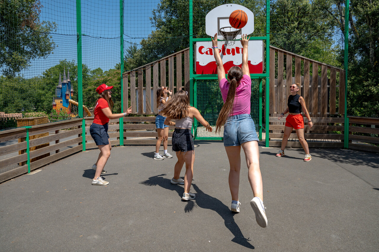 Jongeren basketballen op multisportterrein op camping CAPFUN Palombi�re in Sarlat.